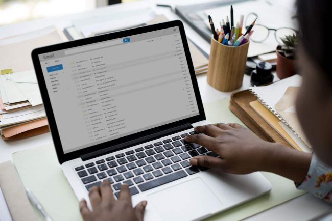 Hands typing on computer looking at emails